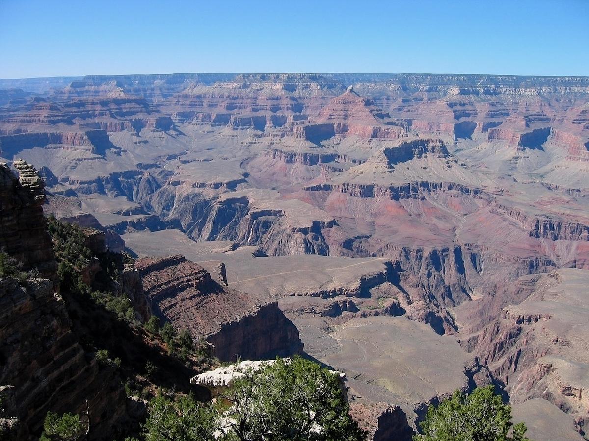A vast, panoramic view of the Grand Canyon showcases its layered rock formations and sweeping landscape.