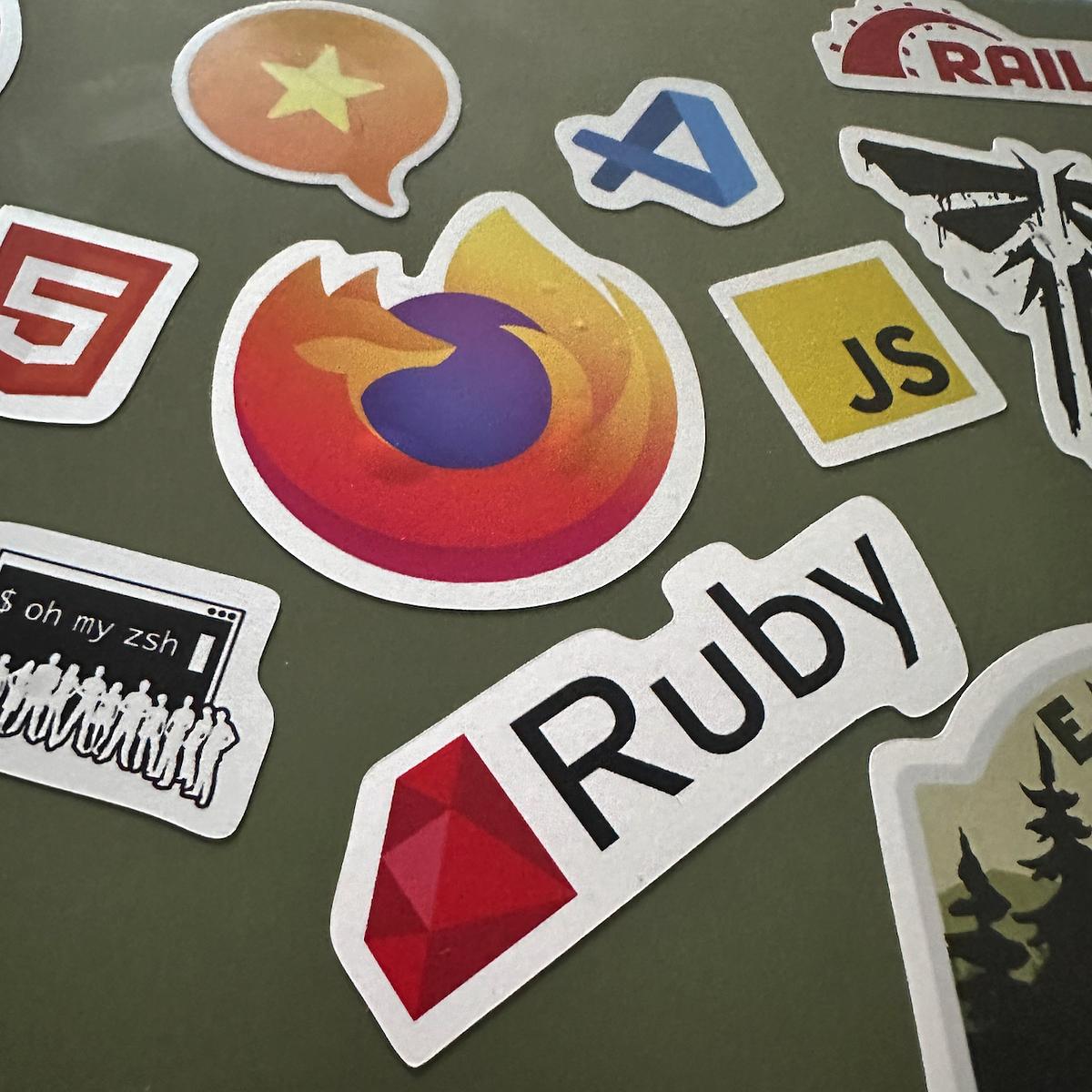 A group of stickers on a laptop cover.