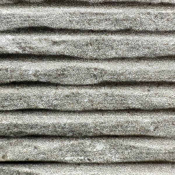 A close-up of a textured, ribbed fabric with a speckled gray pattern.
